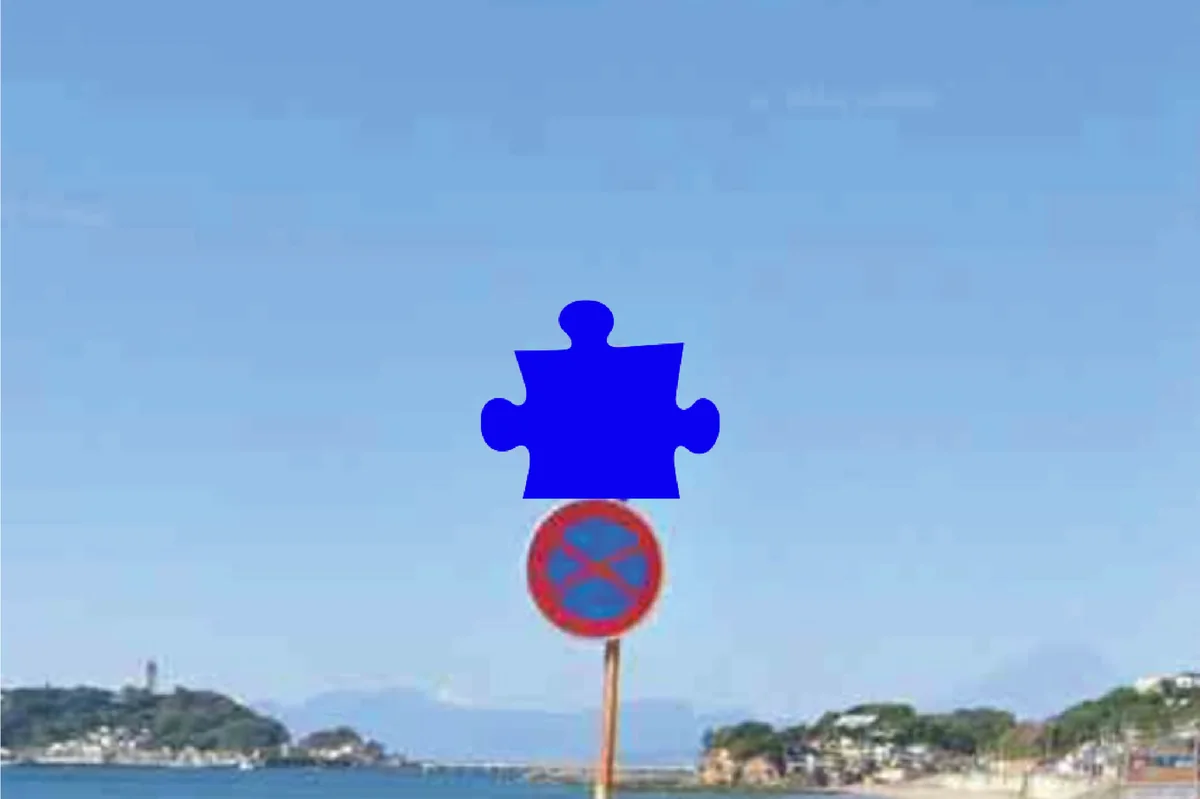国道134号、七里ヶ浜。江の島を望む道路標識の上が、ピースの形に抜けている。